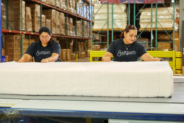 Two earthfoam sewing employees inspect mattress
