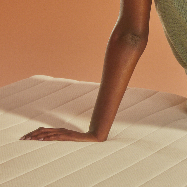 Close up of woman's left hand pressing on mattress